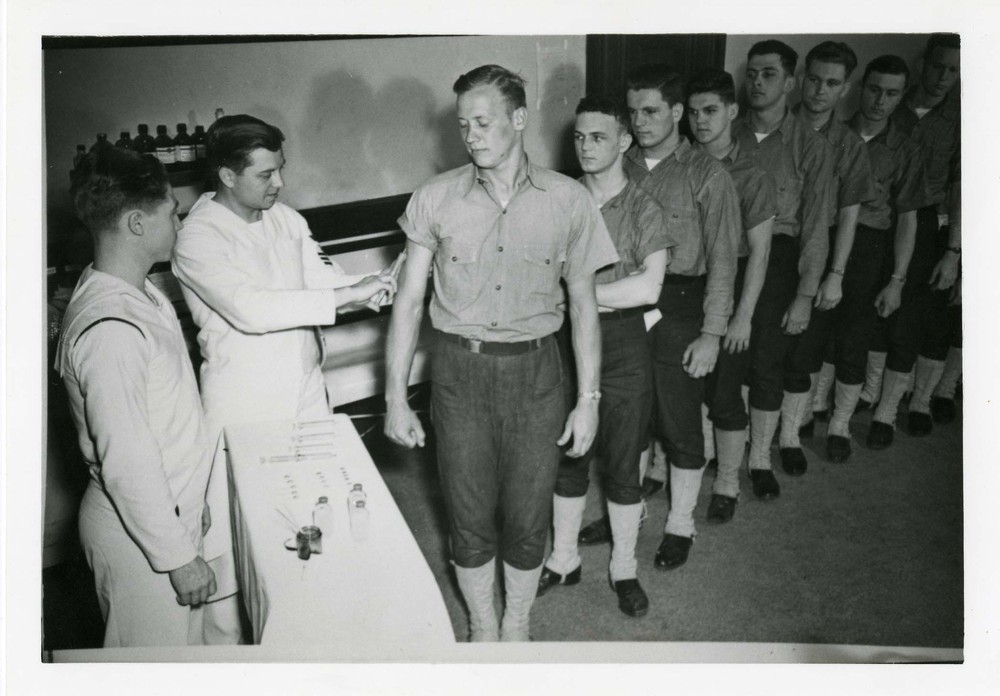 Line of Coast Guardsmen trainees receiving inoculations.