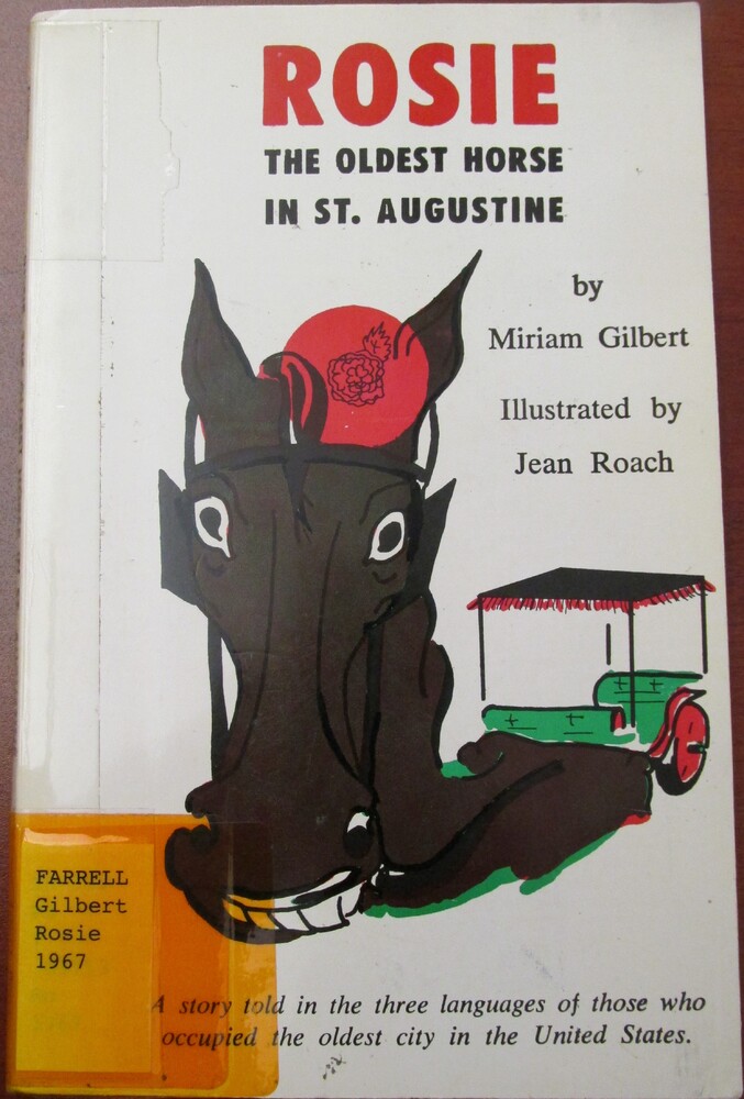 This book is titled "Rosie, the Oldest Horse in St. Augustine: A Story Told in the Three Languages of Those Who Occupied the Oldest City in the United States" written by Miriam Gilbert. The cover of this book is white with "Rosie" in red font and the rest of the type in black. The cover features an illustration of the head of a brown horse with a red hat on. The horse is pulling a green and red carriage.