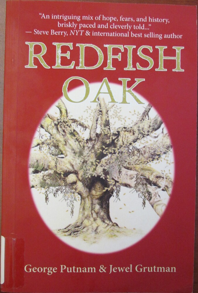 This book is titled "Redfish Oak" by George Putnam and Jewel Grutman. The book cover as a red background and an illustration of a tree in an oval. The oak tree has many large branches and leaves.