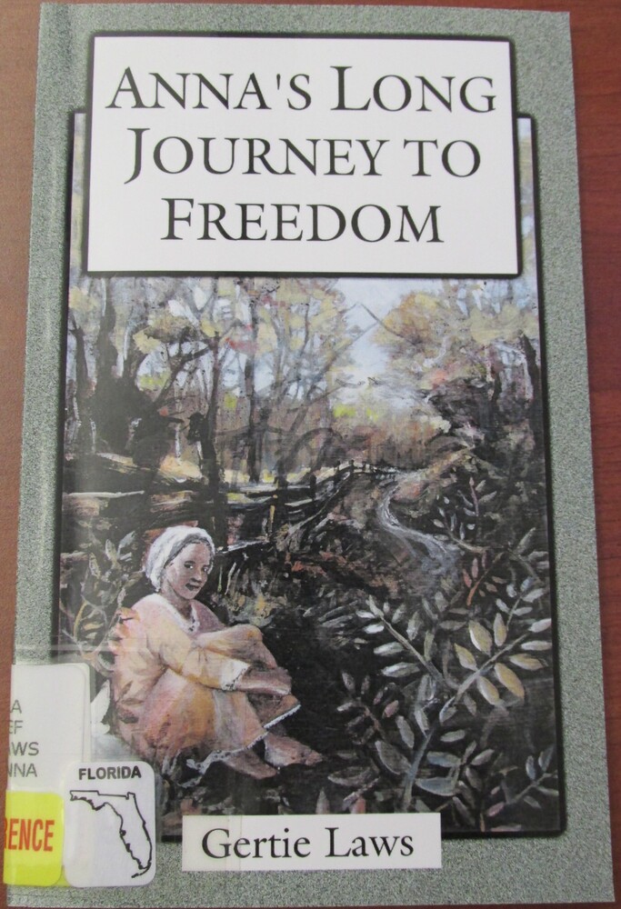 This book it titled "Anna's Long Journey to Freedom" by Gertie Laws. This cover includes an illustration surrounded by a green frame. The illustration is of a young woman in colonial dress sitting with her knees tucked up against her body. She sits next to a fence and is surrounded by trees and foliage.