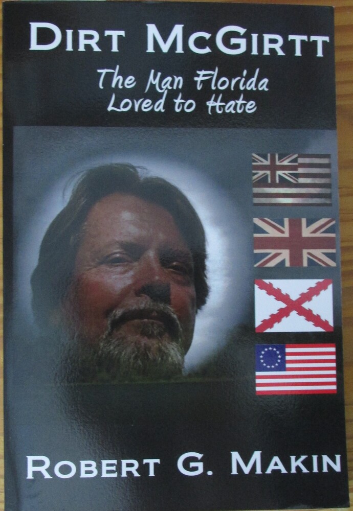 This book is titled "Dirt McGirtt: The Man Florida Loved to Hate" by Robert G. Makin. The book cover includes a depiction of a man with gray hair and a gray beard. He is surrounded by a white light. To the right of him, there are four flags.