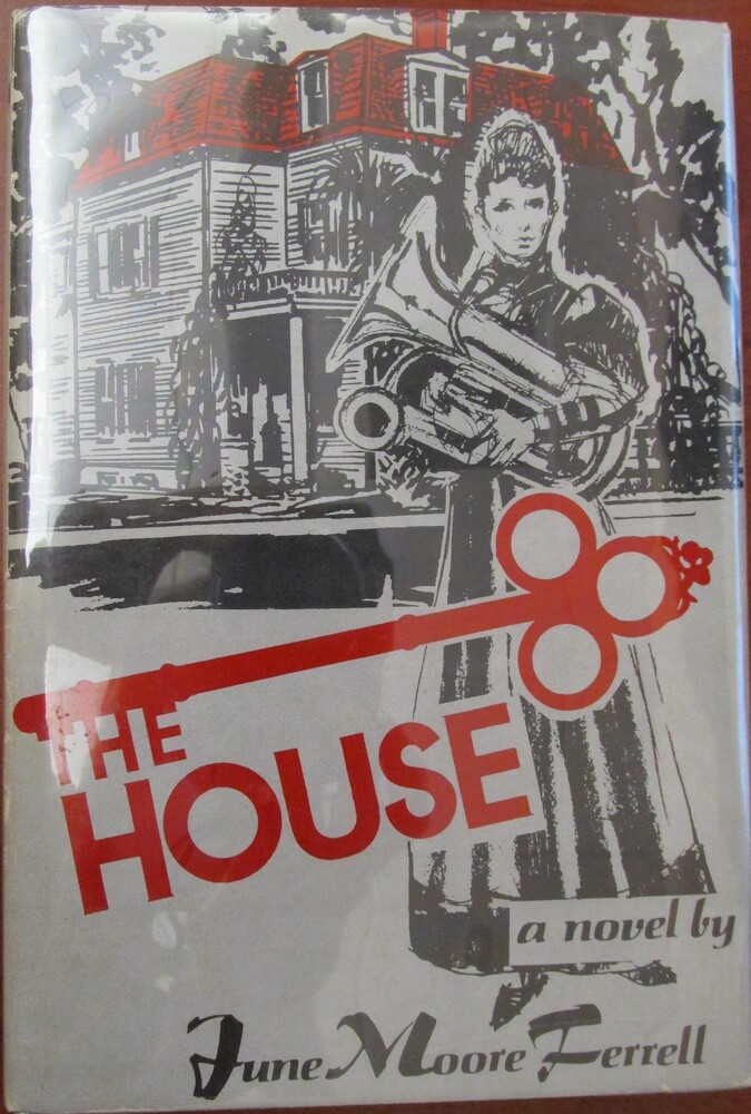 The book is titled "The House" written by June Moore Ferrell. The cover includes a red key across the lower half of the cover, matching the font of the title. Above the key, there is a person in a long dress holding a tuba. Behind them, there is a house that appears to have vines or Spanish moss hanging off it.