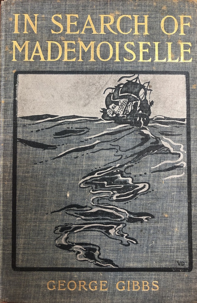 This book is titled "In Search of Mademoiselle" by George Gibbs. The cover of the book is a gray-blue fabric and the title and author are written in gold type. The illustration on the cover of the book is enclosed in a rectangle and includes a drawing of the ocean with a large ship in the upper right hand corner of the rectangle.